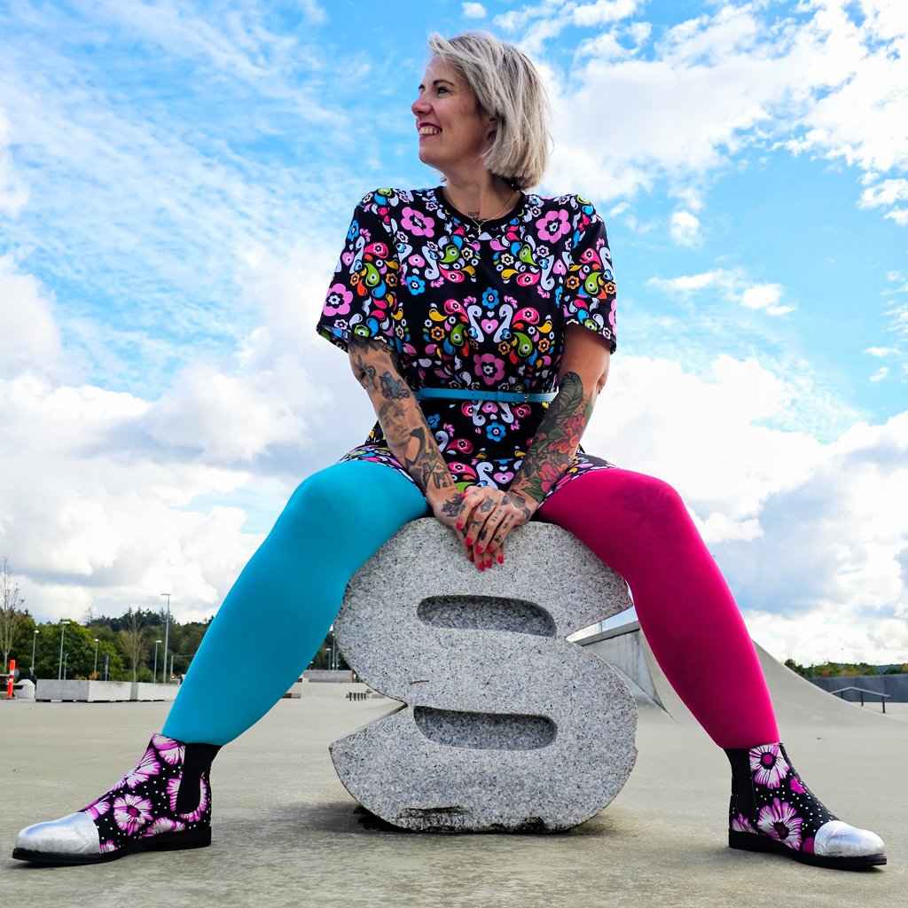 A woman wearing a colorful t-shirt dress by SHALMIAK. Design: PEACOCK LOVE.